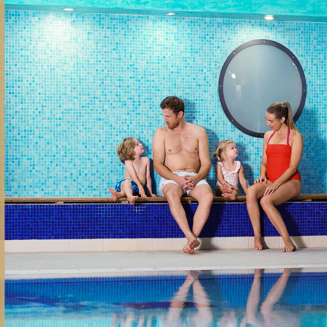 Image of family sitting by the swimming pool at Harbour Club